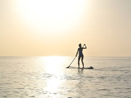 Stand up paddleboarding with sunset