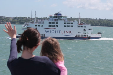 Woman and child waving at a Wightlink ferry